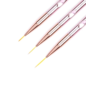 Dettaglio di tre pennelli nail art in oro rosa con manici ergonomici per un design preciso