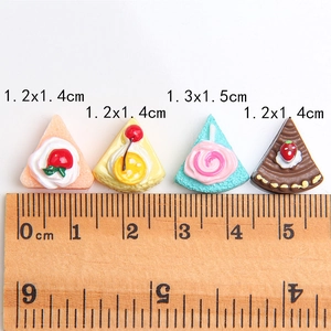 Miniature resin triangle cake charms in four colors with scale ruler for size reference