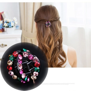 Close-up of mini round hair claw clip with colorful rhinestones on wavy hair