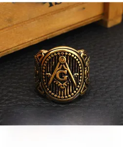 Macro shot of gold stainless steel Masonic ring showing engraved square and compass G symbol