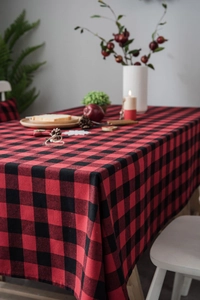 Detail of red and black buffalo check tablecloth with rustic Christmas table setting