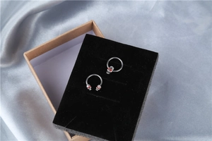 Detail of gothic stainless steel nipple rings with skulls and red crystal eyes