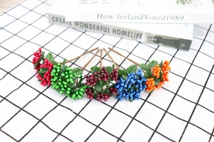 Colorful artificial berry sprigs with glossy berries and leaves for DIY decor