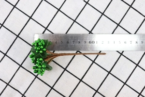 Close-up of artificial green berries with scale ruler for DIY home floral decor