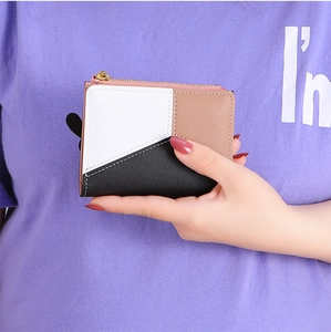 Close-up of three-color patchwork wallet with gold zipper closure and leather texture
