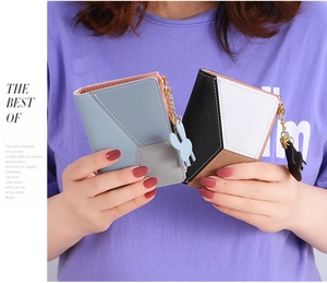 Detail of two-fold short wallets with contrast stitching, gold zippers, and rabbit charms