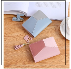Detail of short bifold wallets with contrast stitching, tassels and rabbit charms