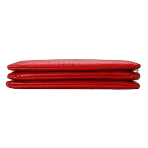 Detail of red leather crossbody bag featuring three-tier accordion compartments and silver zipper
