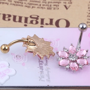 Macro detail of pink sunflower belly button ring with teardrop crystals and gold plating