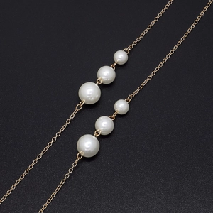 Elegant gold-plated eyewear chain featuring six high-luster white pearls on a black background