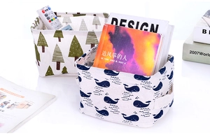 Detail of canvas storage baskets featuring tree and whale prints with side handles