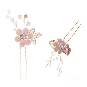 Close-up of pink fabric flowers and faux pearls on golden bridal U-shaped hair pins