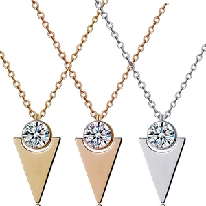 Detail of three-color cross pendants with round zircon inlay in gold, silver and rose gold