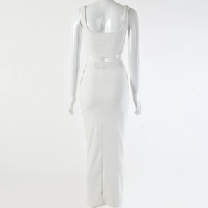Rear view of white ribbed knit two-piece set featuring a crop top and a maxi skirt on a mannequin