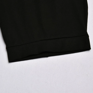Close-up detail of the black ribbed knit fabric and cuff texture on the women's set