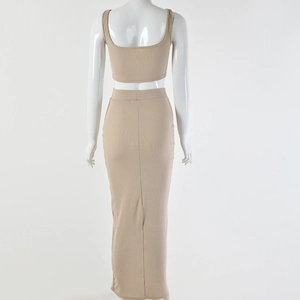 Rear view of a beige ribbed knit two-piece set featuring a cropped top and a high waist maxi skirt