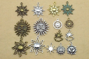 Flat lay of assorted sun charms in antique silver and bronze for DIY jewelry making