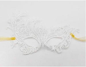 Detailed view of white embroidered lace mask with elegant golden silk ribbons on plain background