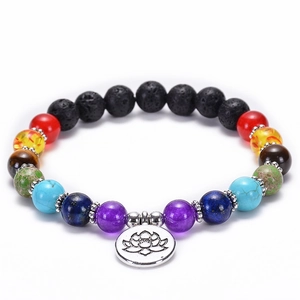 Detail of 7 chakra natural stone beads and silver lotus pendant on black volcanic lava bracelet