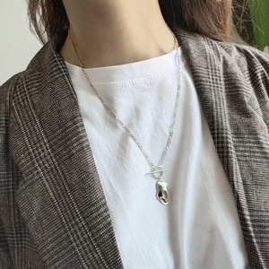 Detailed view of sterling silver geometric pendant with OT toggle clasp on a model
