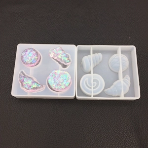 Macro detail of silicone mold for resin jewelry with glitter pastry shapes on black leather
