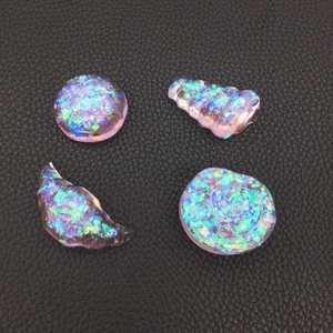 Macro view of four holographic resin ocean shells with vibrant purple and blue opal effect