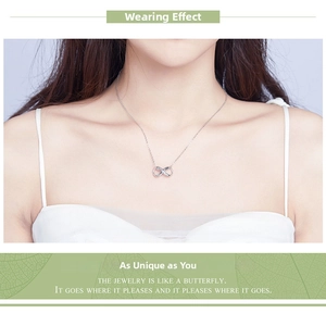 Elegantly worn silver infinity charm necklace featuring sparkling cubic zirconia details