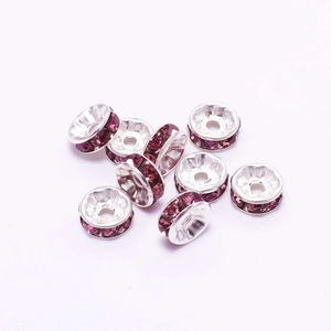 Macro view of silver spacer beads with purple rhinestones for DIY jewelry making