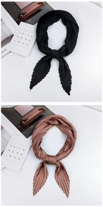 Detailed view of pleated silk scarves in black and dusty pink with elegant textures