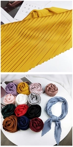 Detailed view of high-density pleated scarves in various colors and smooth silk textures