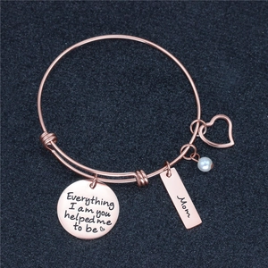 Detail of rose gold bracelet with Mom tag and Everything I am you helped me to be engraving