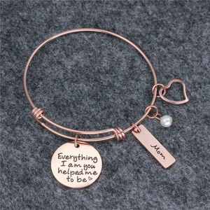 Macro shot of rose gold adjustable bracelet with pearls, heart charms and Mom engraving