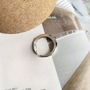 Close-up of polished minimalist silver ring placed on an artistic magazine background