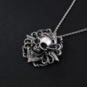 Gothic skull pendant in stainless steel with intricate floral patterns on a rope chain