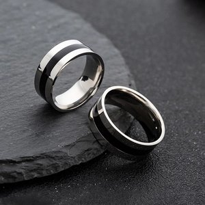 Close-up of dual wide silver stainless steel rings with black enamel inlay on stone