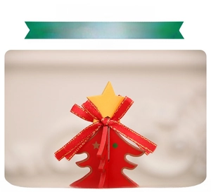 Close-up of wooden Christmas music box with a yellow star and red festive ribbon bow