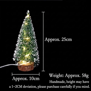 Close-up of mini cedar Christmas tree with warm LED lights and natural wooden base