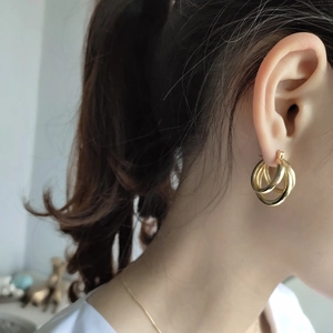 Elegant gold 925 silver triple hoop earrings worn by a model in a minimalist style