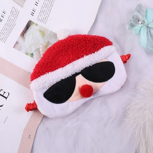Flat lay of plush Christmas elk sleep mask with sunglasses on white textured background