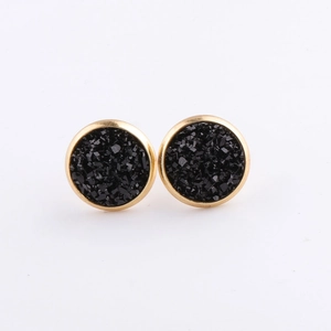 Close-up of 10mm gold stainless steel round stud earrings with black mineral crystal inlay