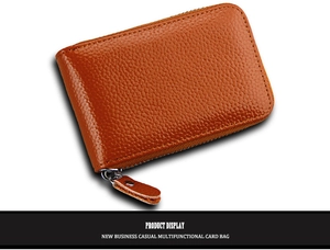 Detailed close-up of brown litchi grain leather texture on multifunctional zip card holder