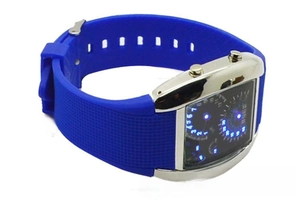 Detail of blue LED watch with silver square metal case and textured silicone strap