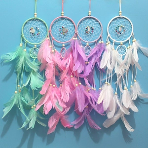 Detail of four colorful dreamcatchers with feathers in green, pink, purple, and white