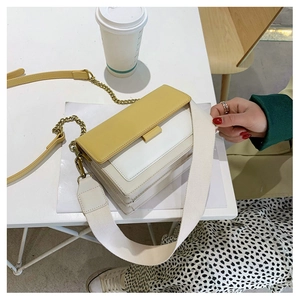 Detailed top view of a yellow and white contrast crossbody bag with two interchangeable straps