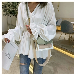 Three-tone crossbody square bag with wide fabric strap styled with casual V-neck outfit