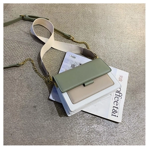 Flat lay of vintage contrast-color crossbody bag with dual shoulder straps and gold hardware
