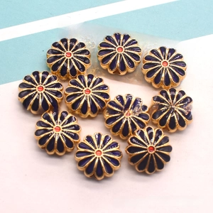 Close-up of DIY flower beads with blue enamel and gold trim for jewelry making