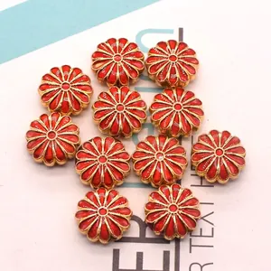 Detailed macro view of red and gold alloy sunflower beads for DIY jewelry crafting