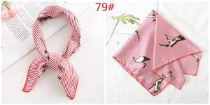 Macro detail of silk scarf with red and white stripes featuring crane prints