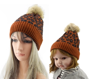 Detail showing matching leopard print knit beanies for parent and child with faux fur poms